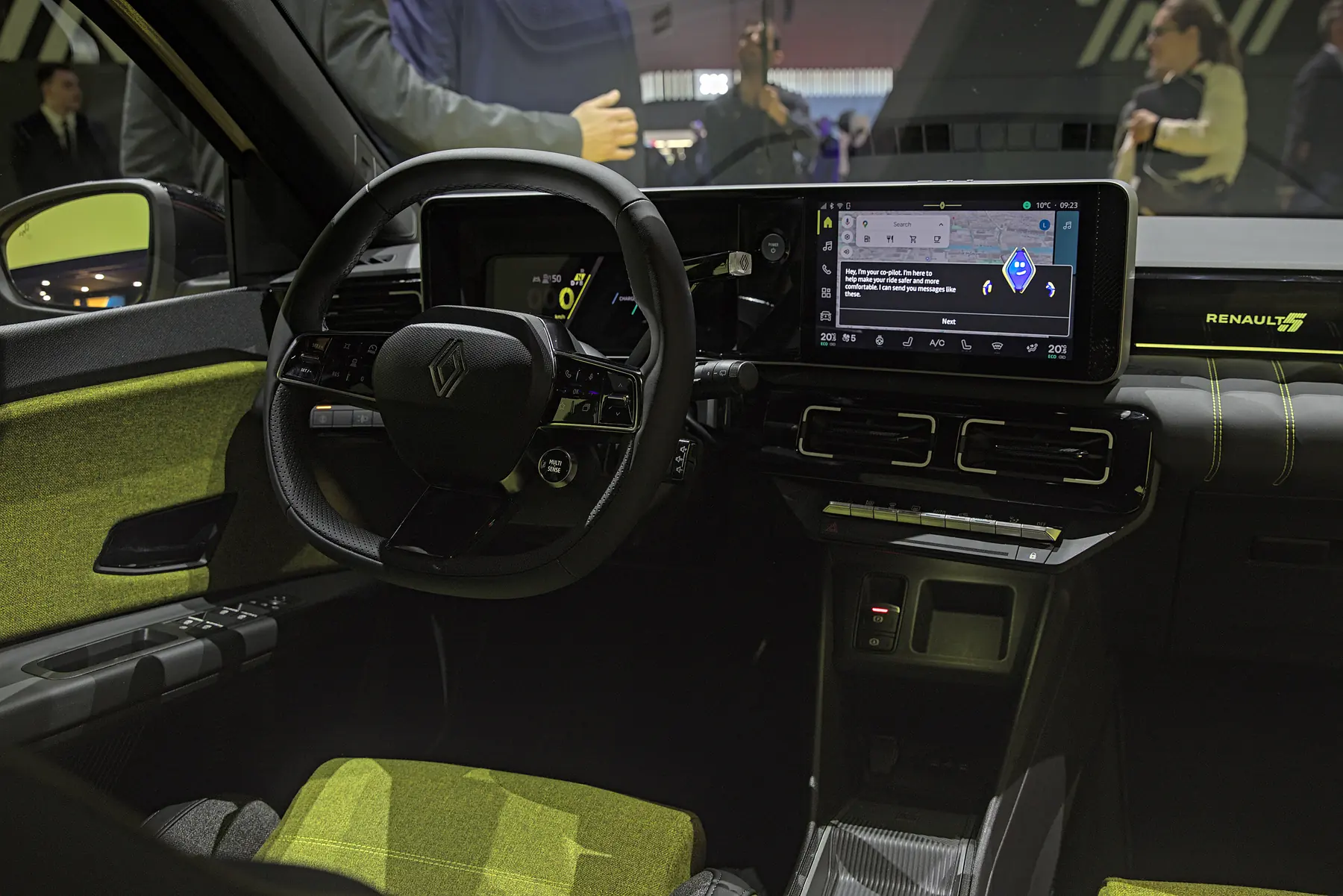 Renault 5 cabin with yellow-accented textile upholstery, steering wheel and central display